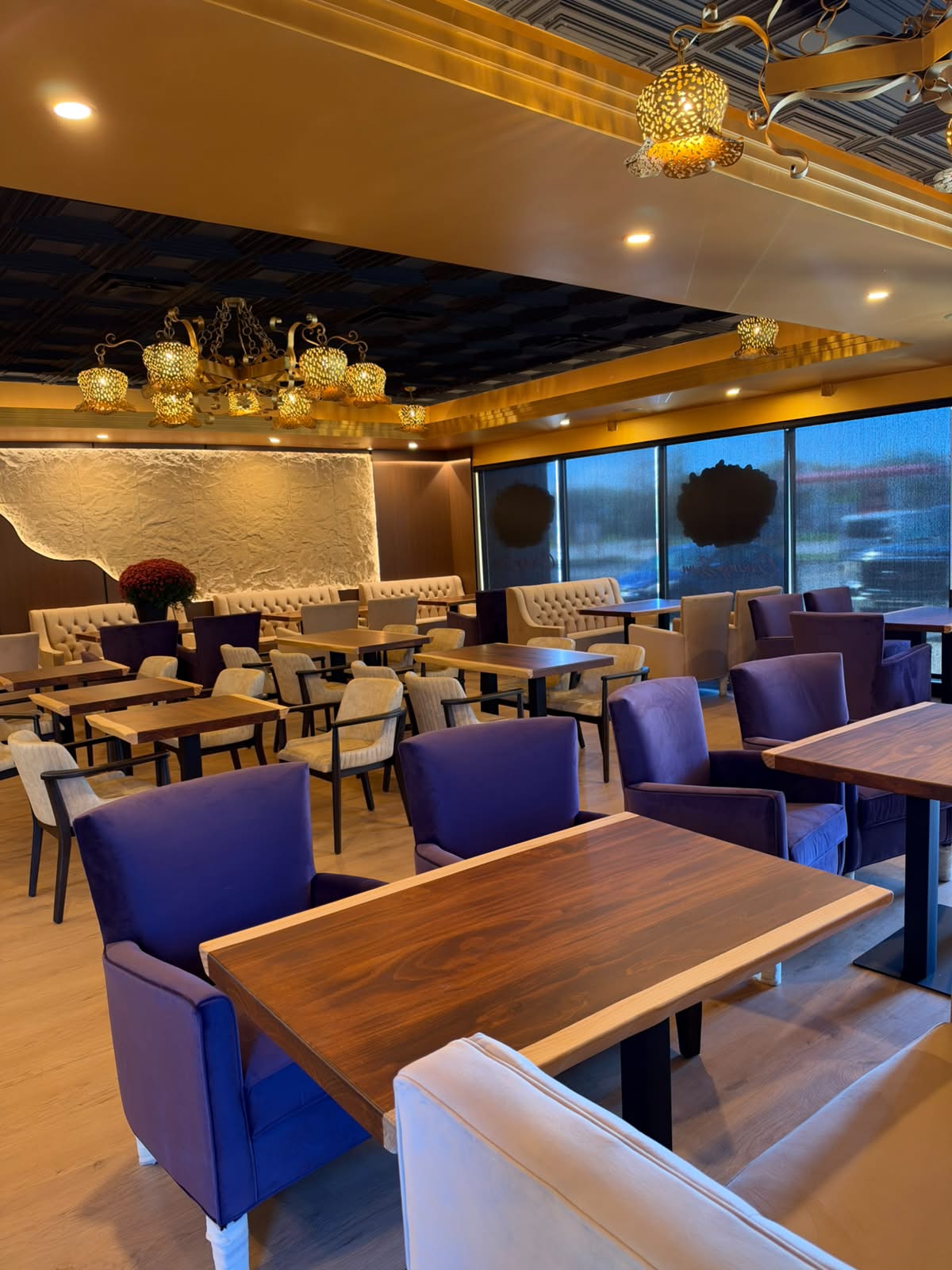 Plum armchairs and wood tables overlooking the café windows
