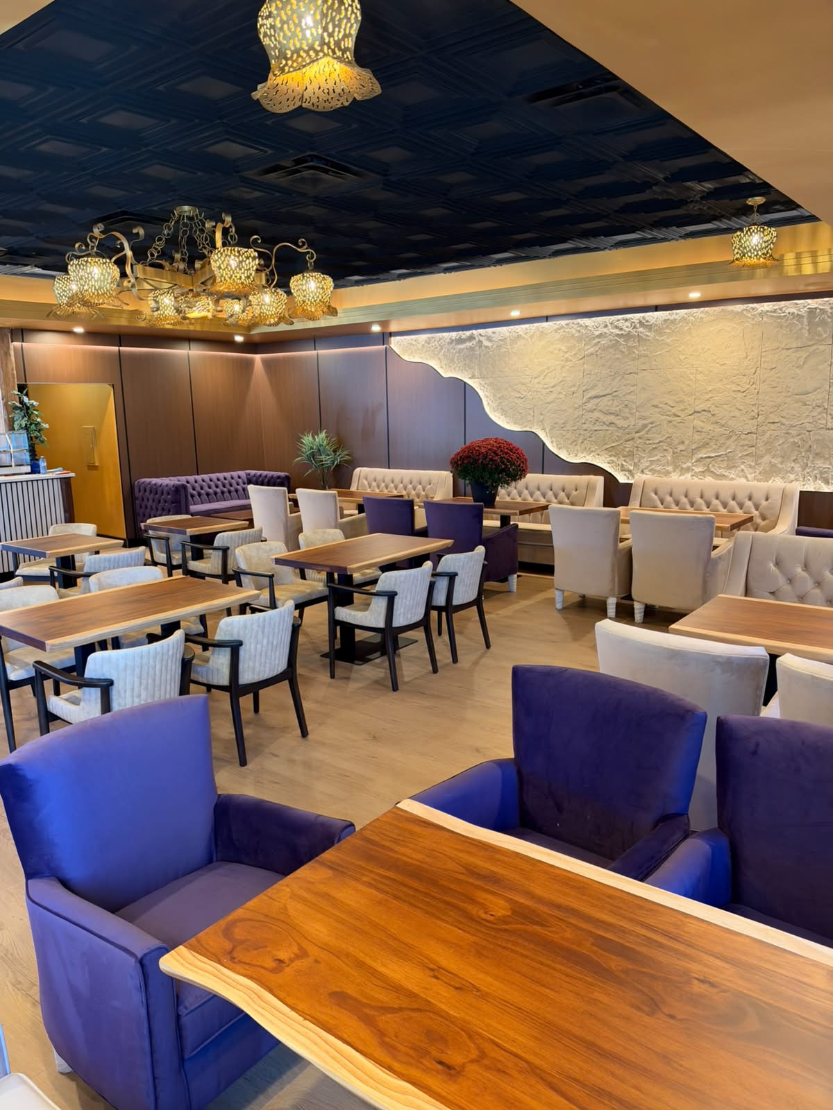 Plum velvet chairs, wood tables and gold chandeliers in the Lavend'Or lounge